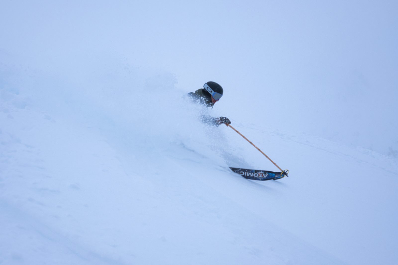 A skier carving on a sunny piste